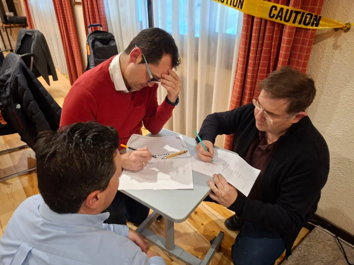 Participantes trabajando juntos en un reto de mesa